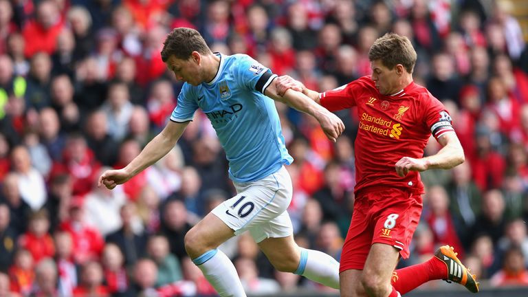 Steven Gerrard of Liverpool challenges Edin Dzeko of Manchester City 