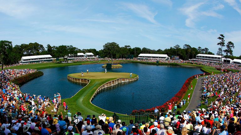 A gallery of fans watch as Rickie Fowler of the United States putts on the 17th green during the third round of THE PLAYERS