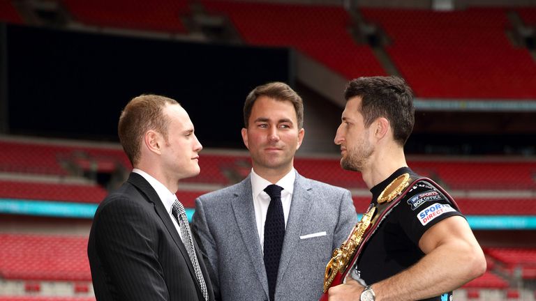 Promoter Eddie Hearn stands inbetween Carl Froch and George Groves as they go head to head during a press conference 