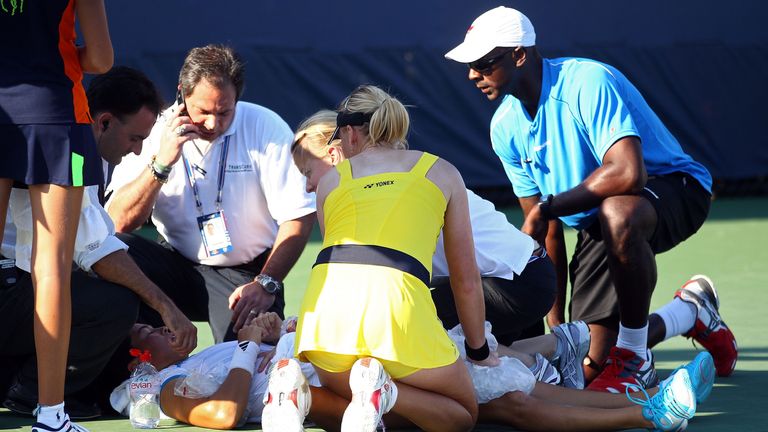 NEW YORK, NY - AUGUST 30 2011:  Jamie Hampton lays on the court after an injury as her opponent Elena Baltacha (in yellow) assists 