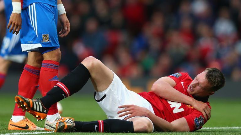 Phil Jones of Manchester United holds his shoulder after sustaining an injury against Hull City