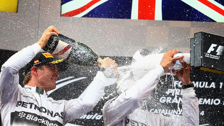  Nico Rosberg sprays champagne over race winner Lewis Hamilton