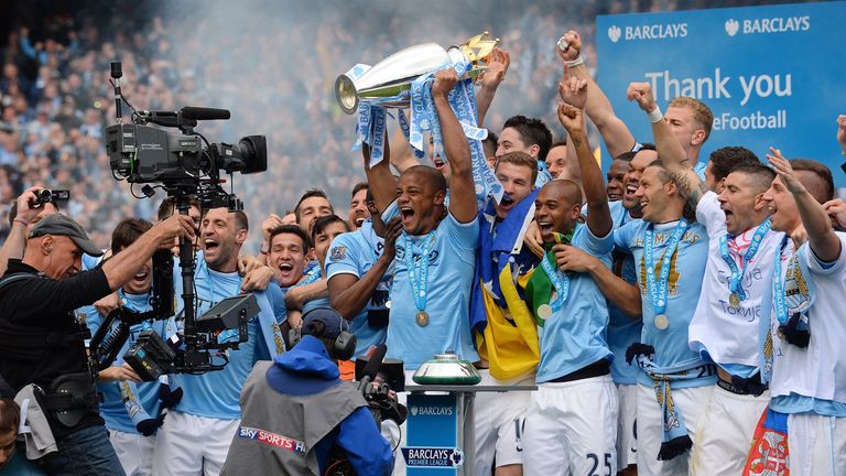 Manchester City's Vincent Kompany celebrates with the trophy after his team won the Premier League