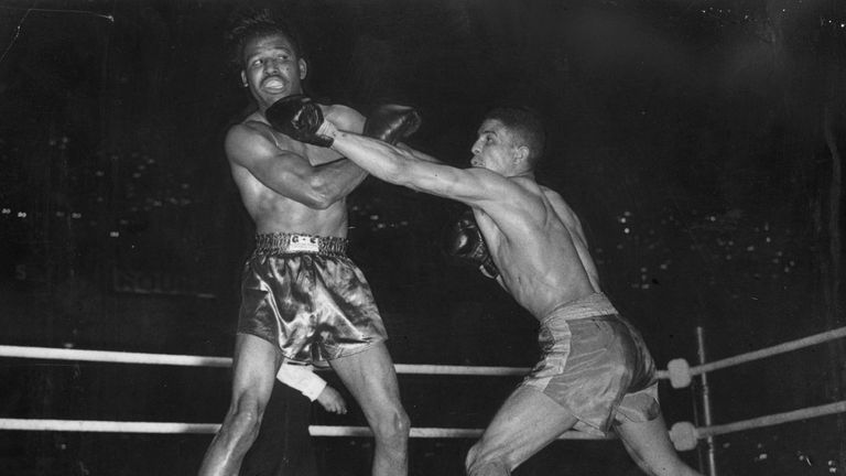 Randy Turpin (right) lands a straight left to Sugar Ray Robinson's chin