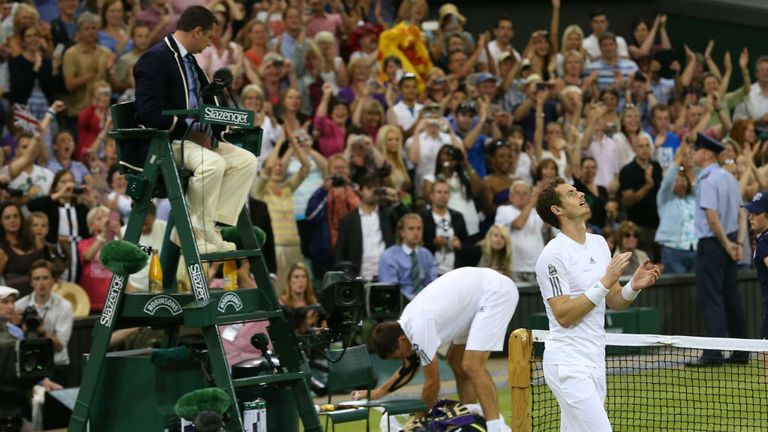 Andy Murray celebrates victory as Jerzy Janowicz of Poland prepares to leave Centre Court