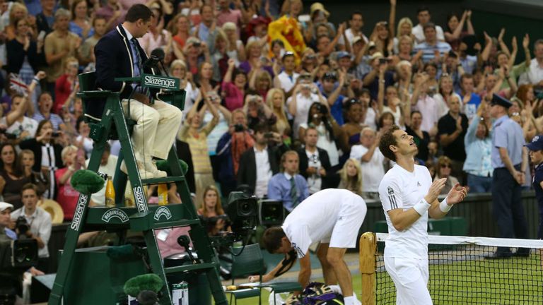 Andy Murray celebrates victory as Jerzy Janowicz of Poland prepares to leave Centre Court