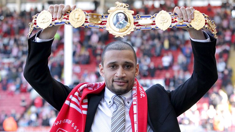 Ex-Sheffield United player Curtis Woodhouse holds aloft his British light-welterweight belt before a game at Bramall Lane on 2013