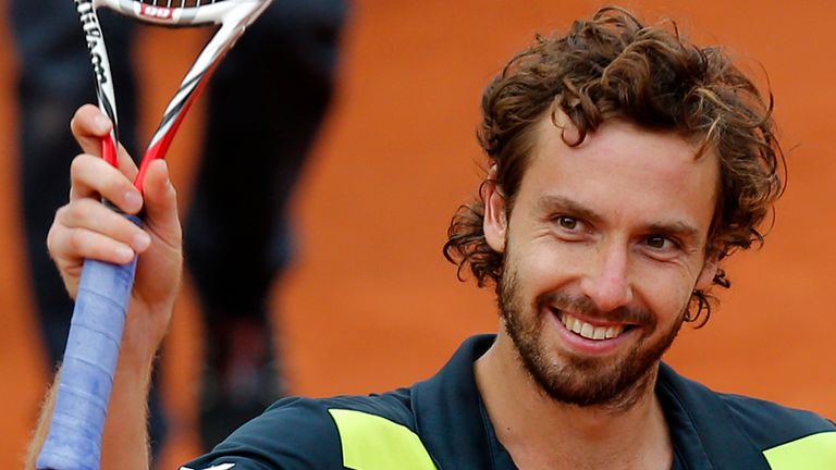 Latvia's Ernests Gulbis raises his racket after defeating Tomas Berdych of the Czech Republic during their quarterfinal match of  the French Open tennis 