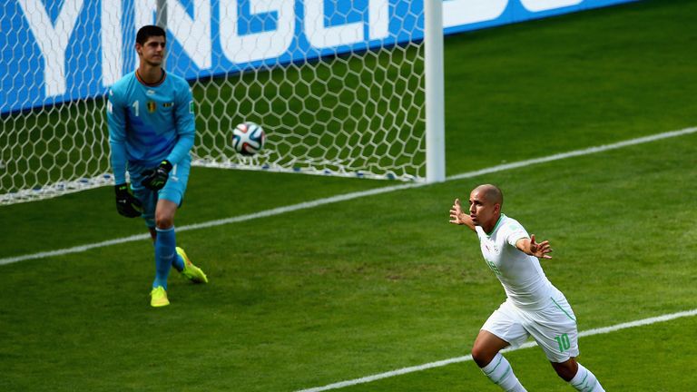 Sofiane Feghouli of Algeria celebrates scoring his team's first goal on a penalty kick past Thibaut Courtois of Belgium 