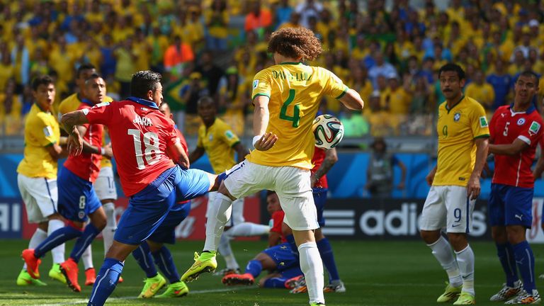 BELO HORIZONTE, BRAZIL - JUNE 28: David Luiz of Brazil scores his team's first goal against Gonzalo Jara of Chile looks on during the 2014 FIFA World Cup
