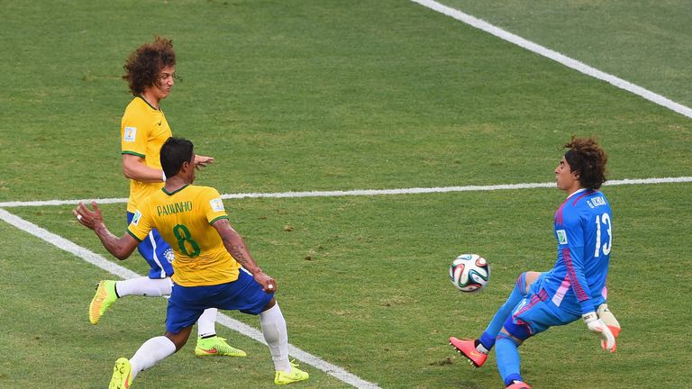 FORTALEZA, BRAZIL - JUNE 17:  Paulinho of Brazil shoots against Guillermo Ochoa of Mexico as David Luiz runs on during the 2014 FIFA World Cup Brazil Group
