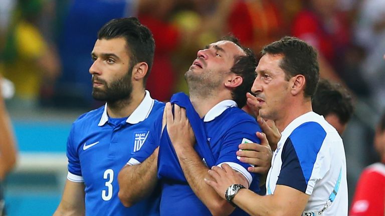 Theofanis Gekas of Greece (C) is consoled by team-mate Giorgos Tzavellas after being defeated by Costa Rica in a penalty shootout at the World Cup