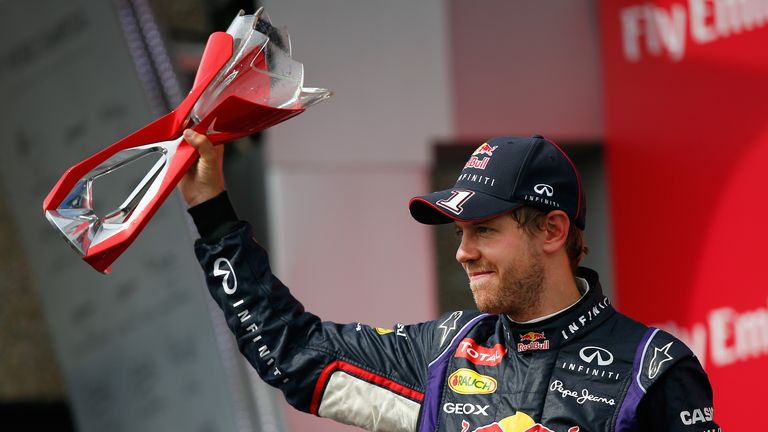 Third placed Sebastian Vettel lifts his trophy