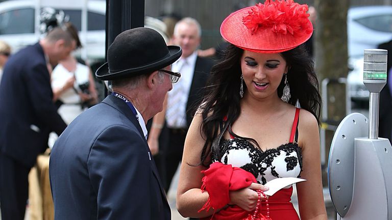 The staff cheerily check over this racegoer's particulars