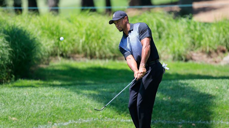 Tiger Woods chips to the practice green in preparation for the Quicken Loans National
