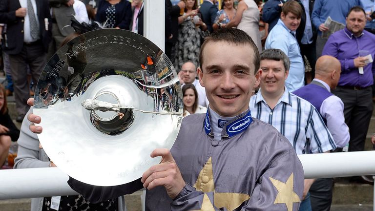 Jockey George Chaloner holds the Northumberland Plate Trophy after his win on Angel Gabrial in the John Smiths Northumberland Plate during the John Smith's