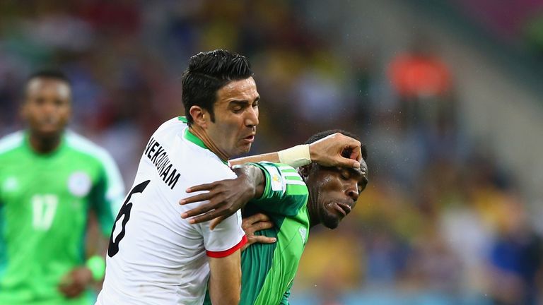 Javad Nekounam of Iran competes for the ball with Emmanuel Emenike of Nigeria 