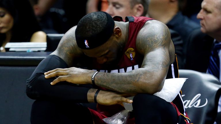 LeBron James #6 of the Miami Heat sits on the bench after leaving the game in the fourth quarter with cramps against the San Antonio Spurs