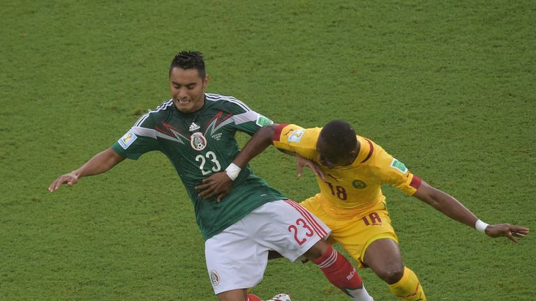 Mexico's midfielder Jose Juan Vazquez (L) challenges Cameroon's midfielder Enoh Eyong during the Group A football match at the 2014 FIFA World Cup