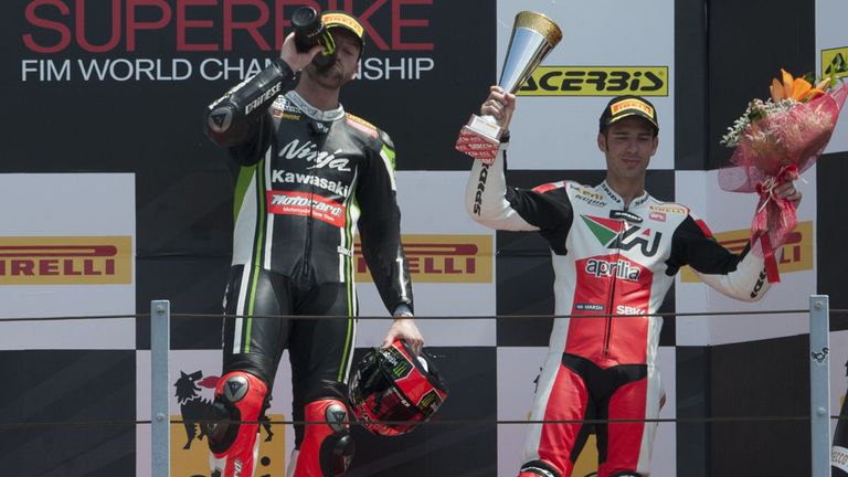 Winner Tom Sykes enjoys his bottle of champagne while third-placed Marco Melandri waves to the crowd at Misano