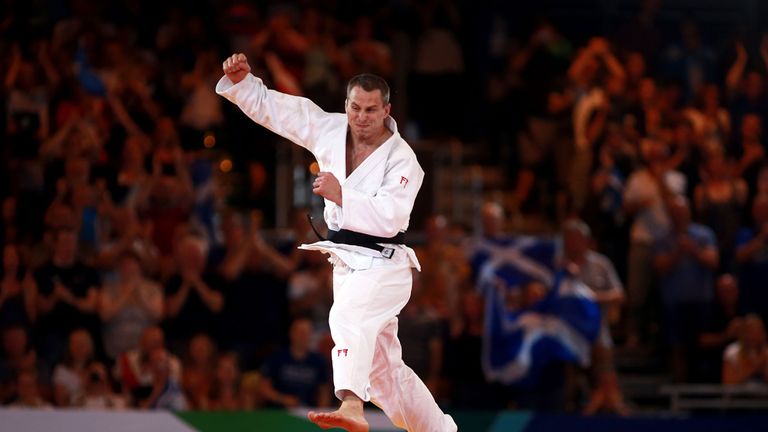 Scotland's Euan Burton celebrates winning gold over Pakistan's Shah Hussain Shah in their Men's 100kg contest at the SECC during the Commonwealth Games