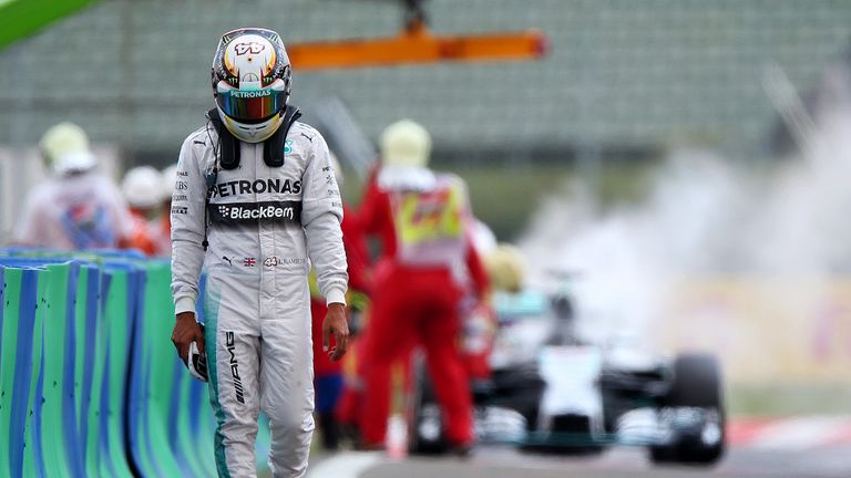 Lewis Hamilton walks away from his smoking Mercedes during qualifying at Hungary