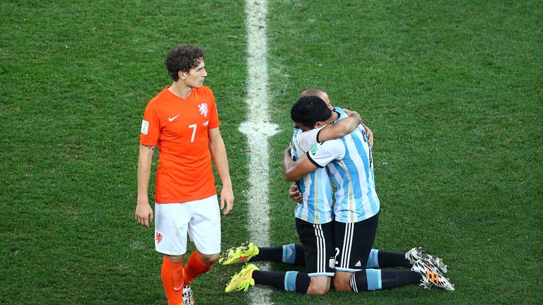 SAO PAULO, BRAZIL - JULY 09: Javier Mascherano and Ezequiel Garay of Argentina celebrate after defeating the Netherlands in a penalty shootout as a dejecte