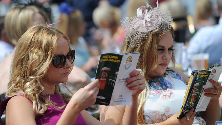 Racegoers study their racecards during the 55th John Smith's Cup day of the 2014 John Smith's Cup Meeting at York Racecourse, York. PRESS ASSOCIATION Photo