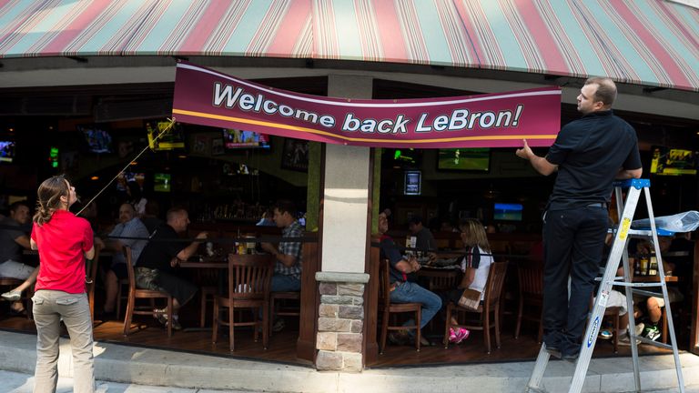 CLEVELAND, OH - JULY 11: Employees of The Tilted Kilt hang a banner to welcome back LeBron James on July 11, 2014 in Cleveland, Ohio. Earlier in the day Ja