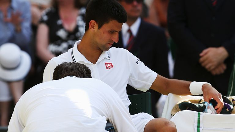 LONDON, ENGLAND - JULY 06:  Novak Djokovic of Serbia receives treatment from the trainer during the Gentlemen's Singles Final match against Roger Federer o