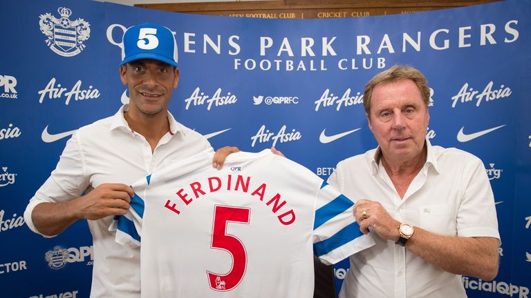 Queens Park Rangers English player Rio Ferdinand (L) and manager Harry Redknapp pose for photographs during a press conference at the Queens Park Rangers f