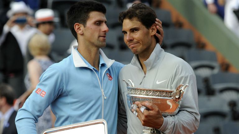 Spain's Rafael Nadal holding the Musketeers winner's trophy, is congratulated by Serbia's Novak Djokovic at the 2014 French Open