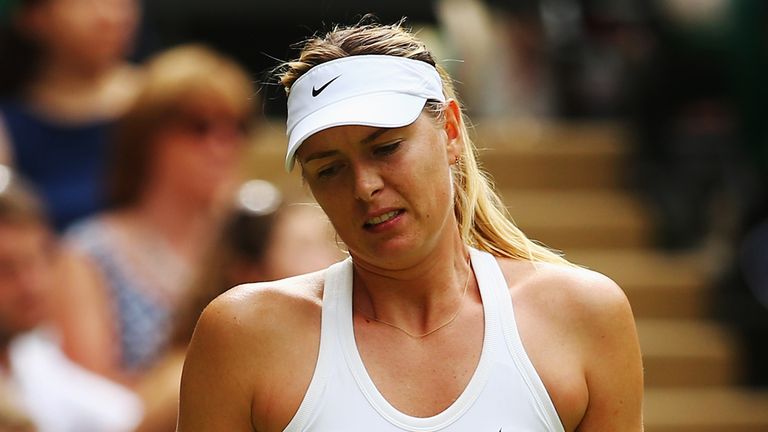 Maria Sharapova of Russia stands dejected during her Ladies' Singles fourth round match against Angelique Kerber of Germany at Wimbledon 2014