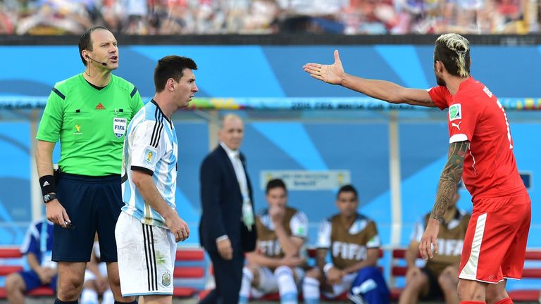 Lionel Messi looks on as Valon Behrami berates referee Jonas Eriksson