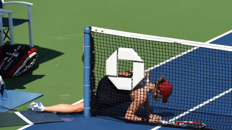 Alize Cornet of France falls after slipping on a mat while playing against Daniela Hantuchova of Slovakia during their 2014 US Open match