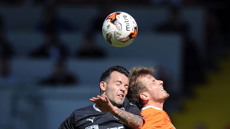 Andrea Orlandi (R) of Blackpool and Ross Wallace of Burnley contest a header during the Pre Season Friendly match at Bloomfield Road