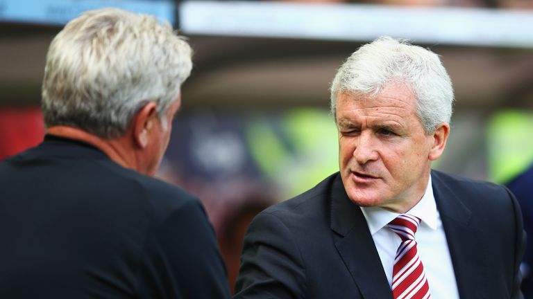 Mark Hughes manager of Stoke City winks at Steve Bruce manager of Hull City (L) as they shake hands
