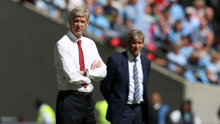 Arsenal manager Arsene Wenger and Manchester City manager Manuel Pellegrini (behind) on the touchline during the Community Shield match at Wembley Stadium,