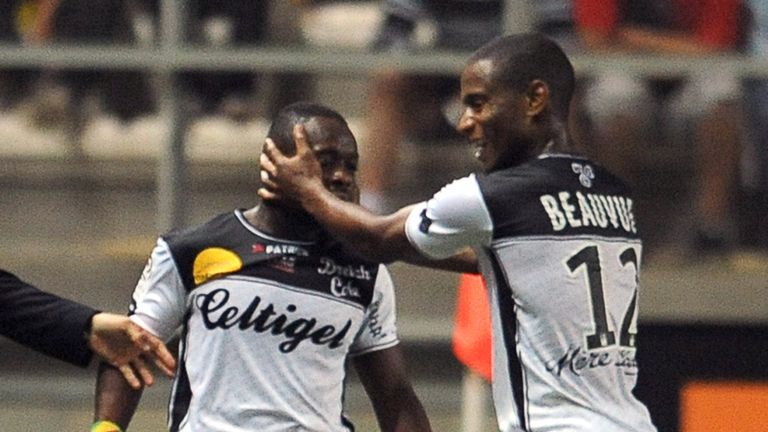 Guingamp's Congolese forward Ladislas Douniama (C) is congratulated by Claudio Beauvue after he scored a goal against Lens