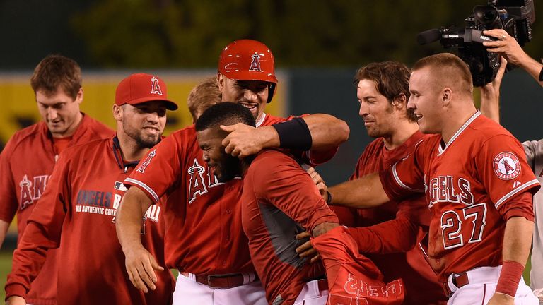 Howie Kendrick #47 (C) of the Los Angeles Angels of Anaheim is congratulated by team-mate Albert Pujols #5