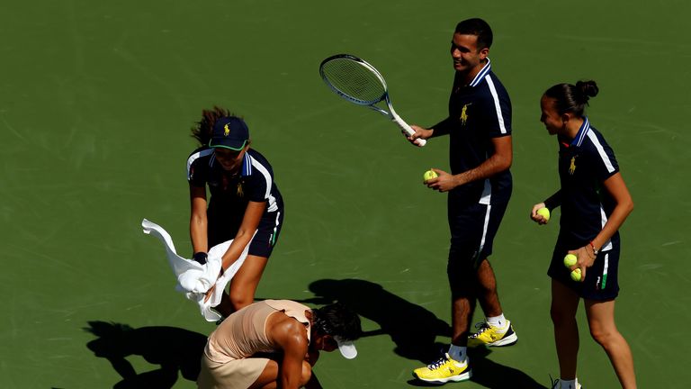 Ball people attempt to catch a honey bee in front of Kimiko Date-Krumm at the US Open
