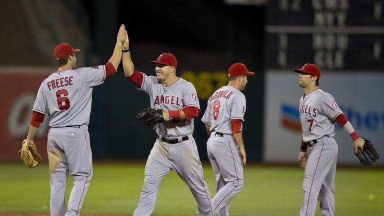 David Freese #6 of the Los Angeles Angels celebrates with Mike Trout #27, John McDonald #8 and Collin Cowgill #7 