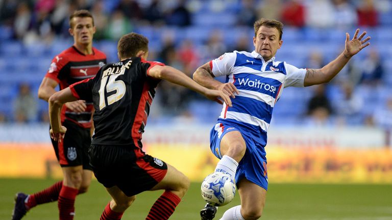 Huddersfield Town's Murray Wallace and Reading's Simon Cox (right) battle for the ball during the Sky Bet Championship match at the Madejski Stadium