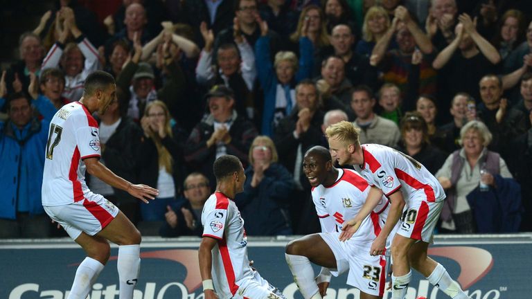 MK Dons English striker Benik Afobe (2nd R) celebrates with teamates after scoring their fourth goal during the English League Cup second round football ma