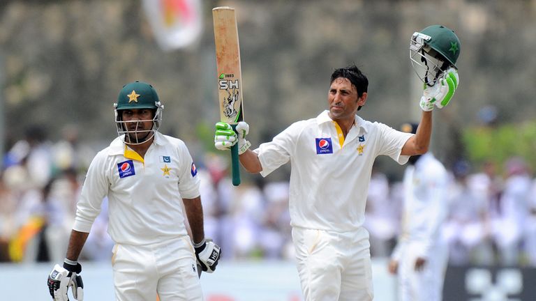Pakistan cricketer Younis Khan (R) raises his bat and helmet in celebration after scoring 150 runs