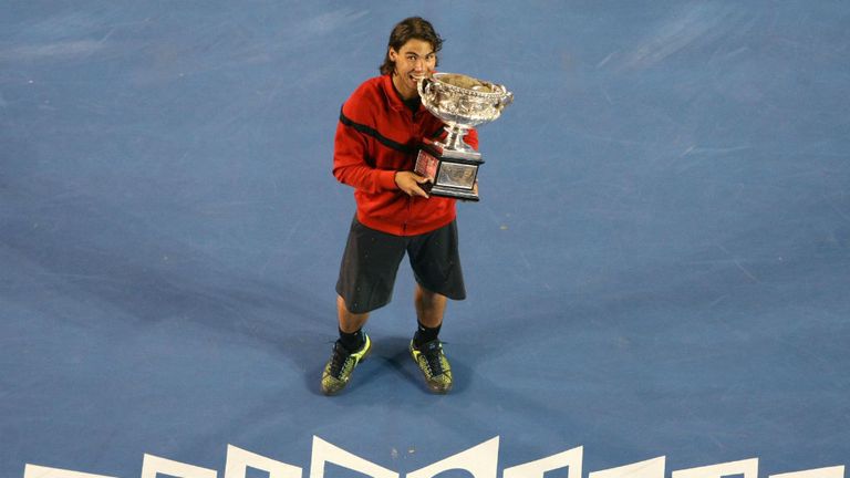 Rafael Nadal holds the trophy as he celebrates defeating Roger Federer after the men's final at the 2009 Australian Open in Melbourne