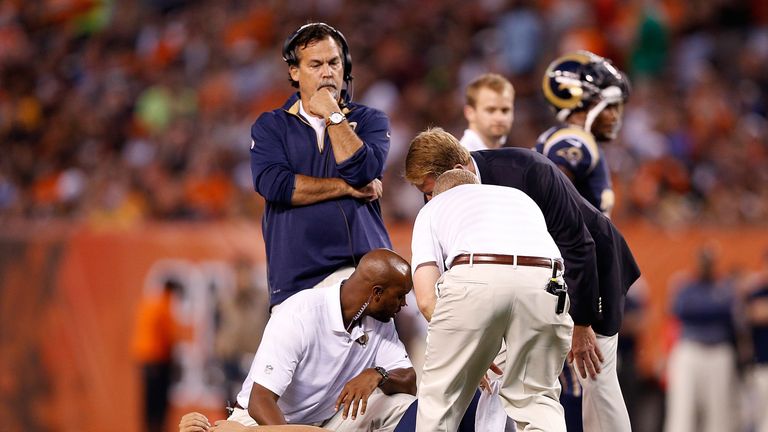 Sam Bradford #8 of the St. Louis Rams is looked at by trainers after being injured against Cleveland Browns