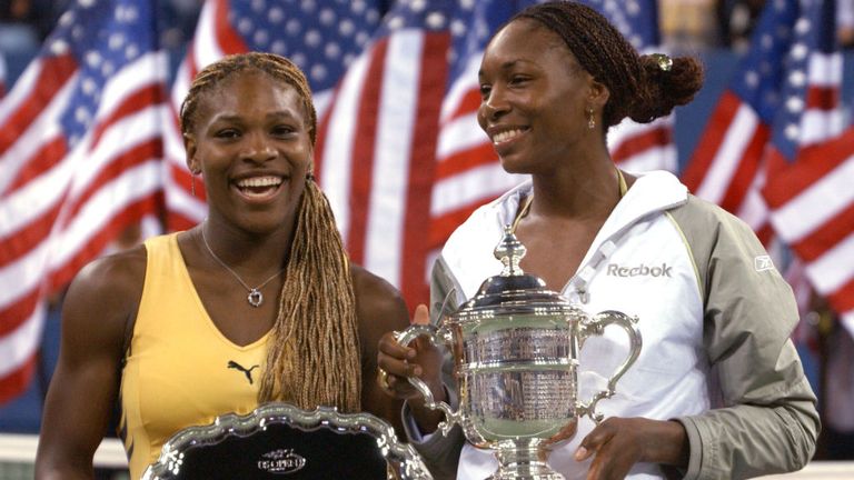 Venus Williams holds her trophy with her sister Serena Williams after the women's final match of the US Open in 2001