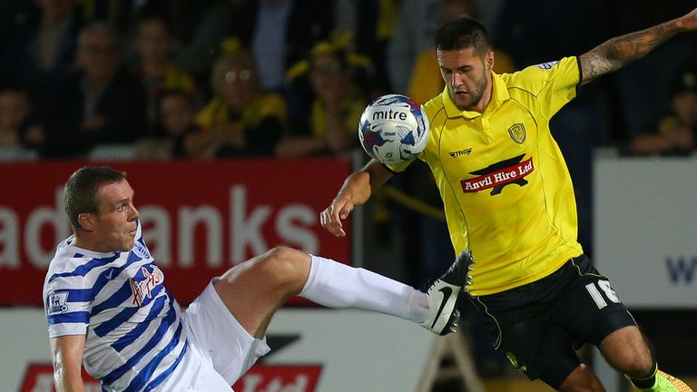 Queens Park Rangers' Richard Dunne and Burton Albion Dominic Knowles compete for the ball during the Capital One Cup Second Round match at the Pir