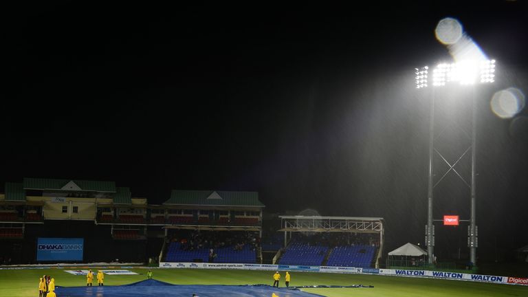 Workers cover the field for a rain delay during a T20 International between the West Indies and Bangladesh at the Warner Park cricket ground in Basseterre,